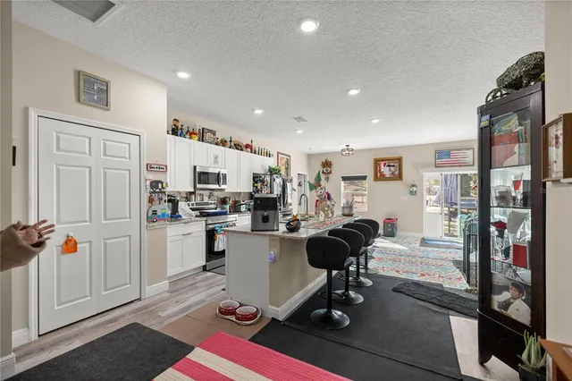 a kitchen with kitchen island wooden floors and stainless steel appliances
