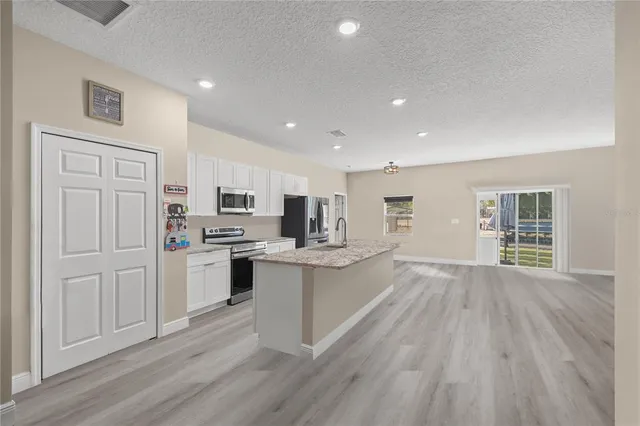 a kitchen with stainless steel appliances kitchen island granite countertop a stove and cabinets