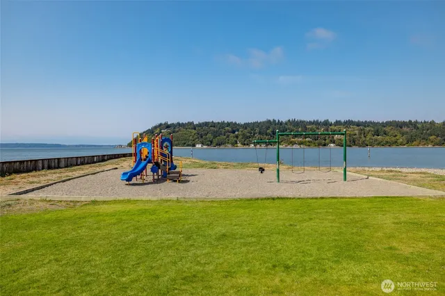 a view of a playground with swimming pool and seating