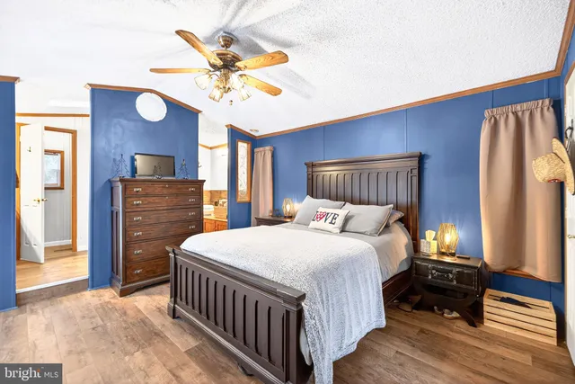 a bedroom with a large bed a chandelier and dresser