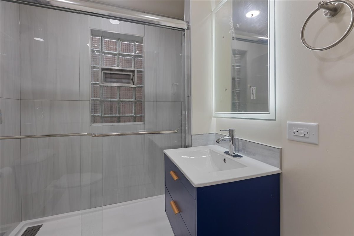 4626 West Monroe Street Chicago, IL 60644 - Photo 30 of 34 a bathroom with a sink vanity and a mirror