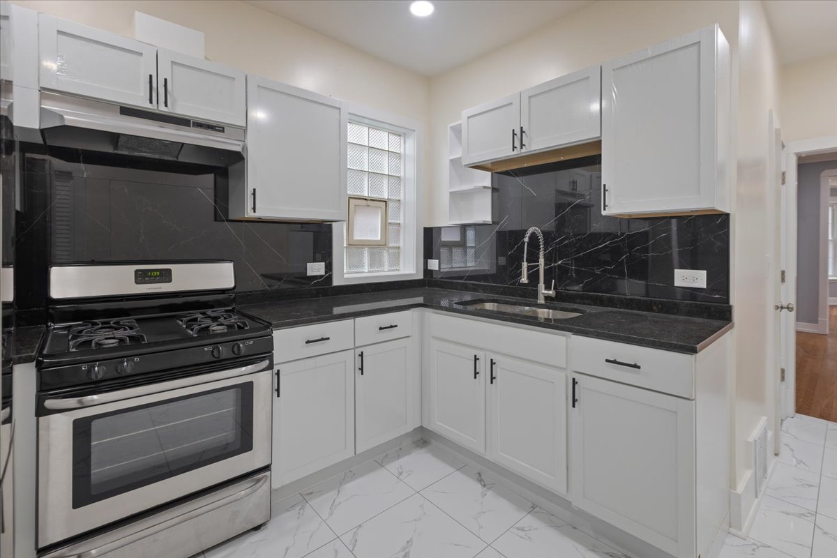 4626 West Monroe Street Chicago, IL 60644 - Photo 33 of 34 a kitchen with granite countertop cabinets stainless steel appliances and a sink