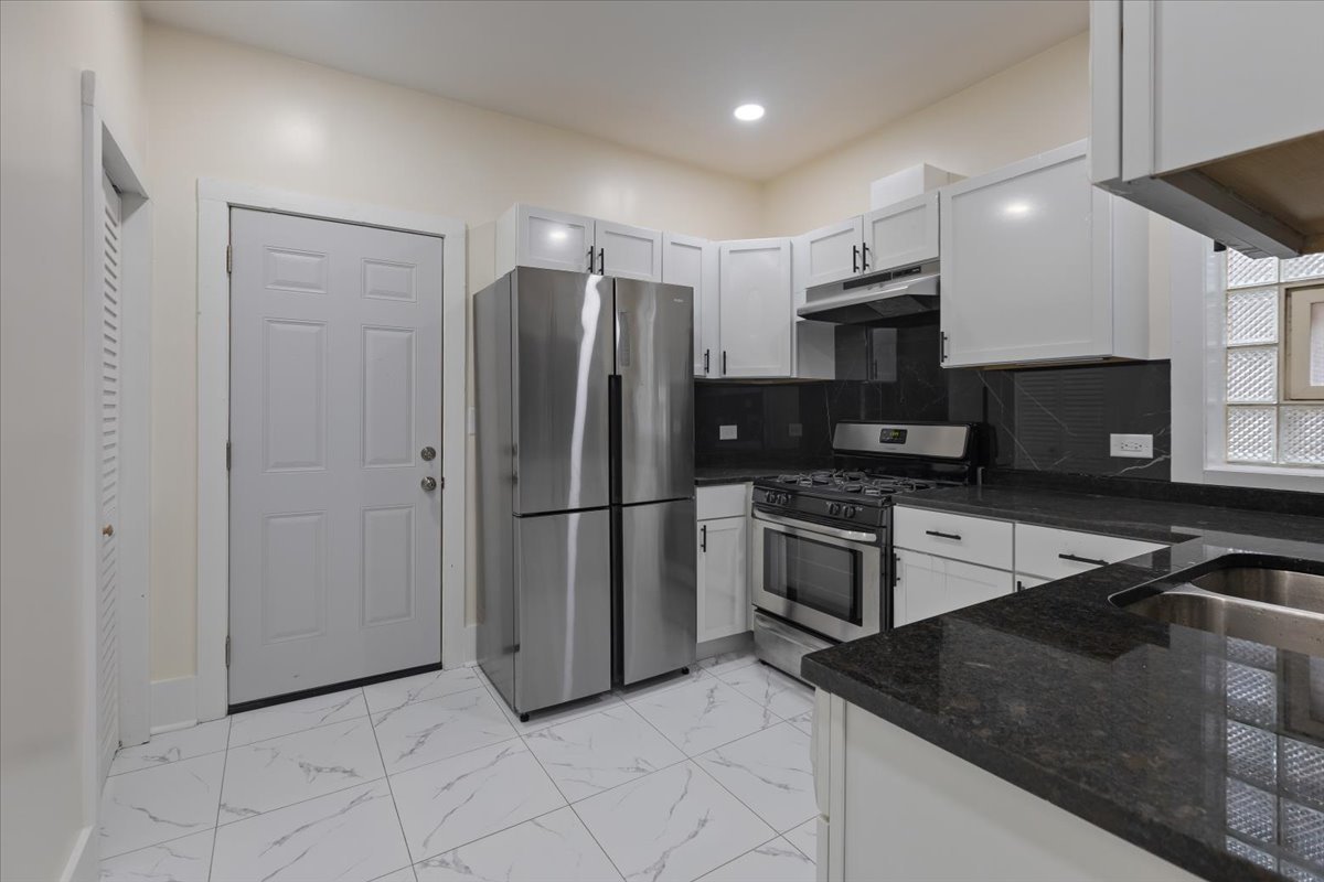 4626 West Monroe Street Chicago, IL 60644 - Photo 34 of 34 a kitchen with stainless steel appliances granite countertop a refrigerator a stove a sink and a microwave