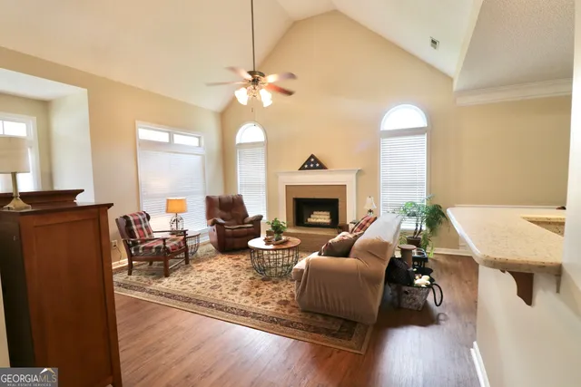 a living room with furniture a fireplace and a chandelier