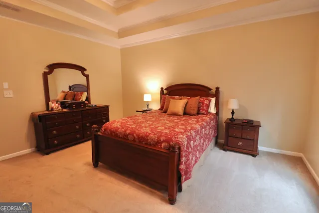 a bedroom with a bed chair and two windows