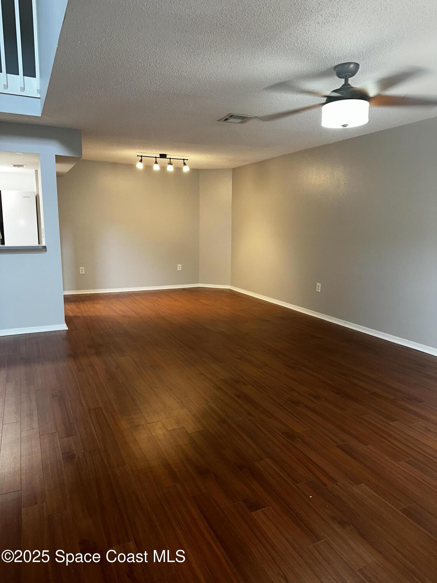723 Players Court Melbourne, FL 32940 - Photo 3 of 15 a view of an empty room with a mirror and wooden floor