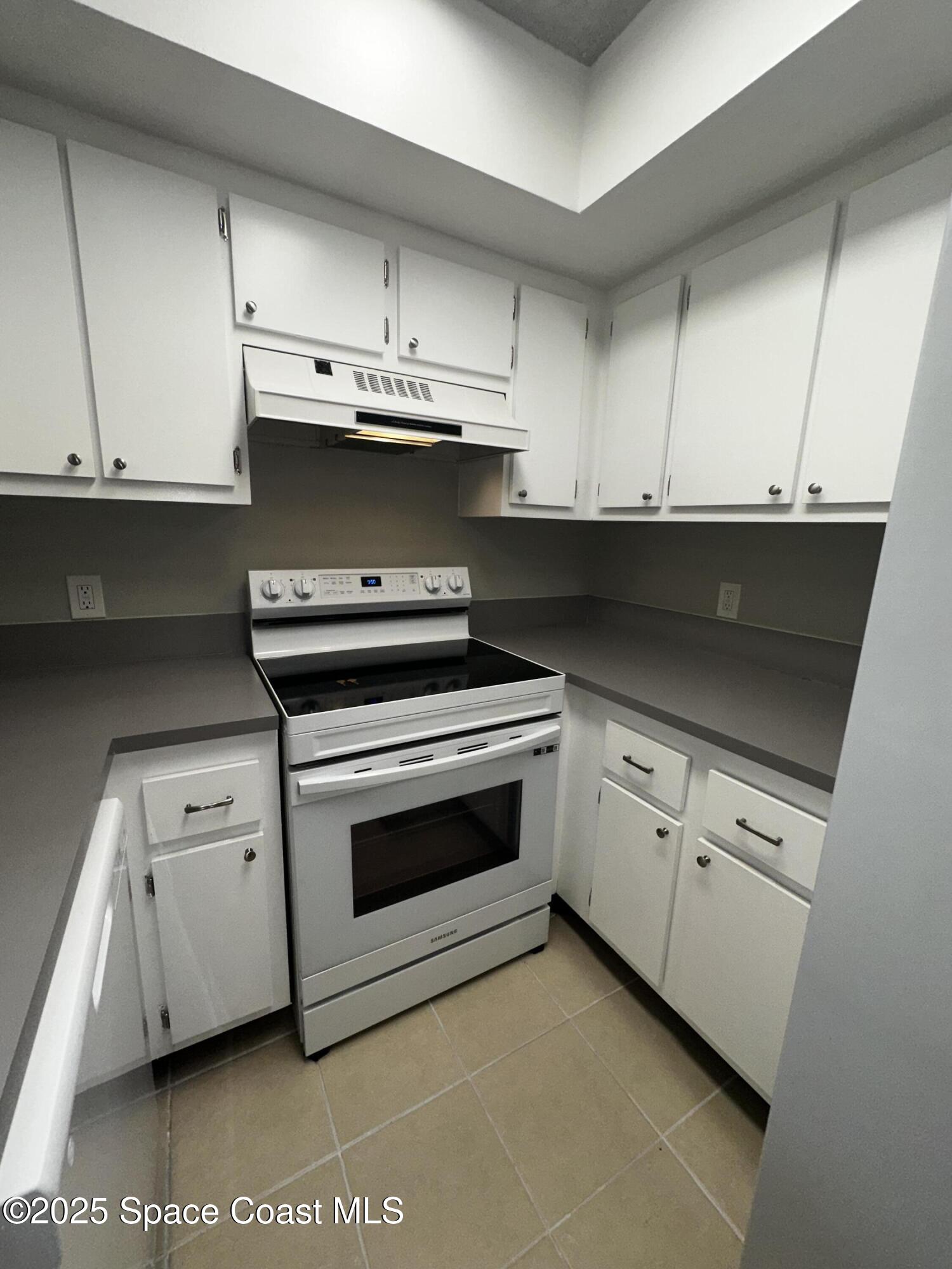 723 Players Court Melbourne, FL 32940 - Photo 6 of 15 a kitchen with granite countertop white cabinets and white appliances