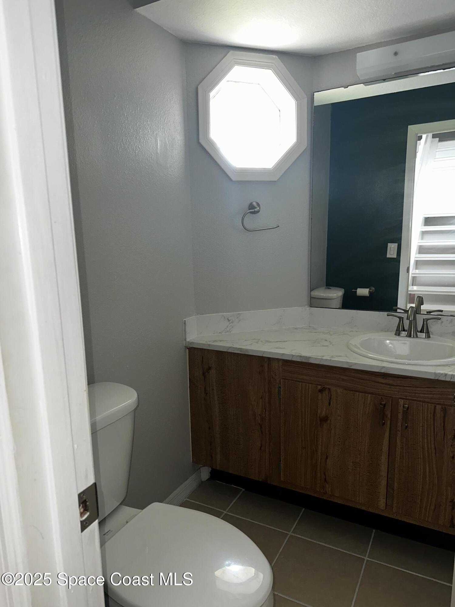 723 Players Court Melbourne, FL 32940 - Photo 8 of 15 a bathroom with a sink a toilet and mirror