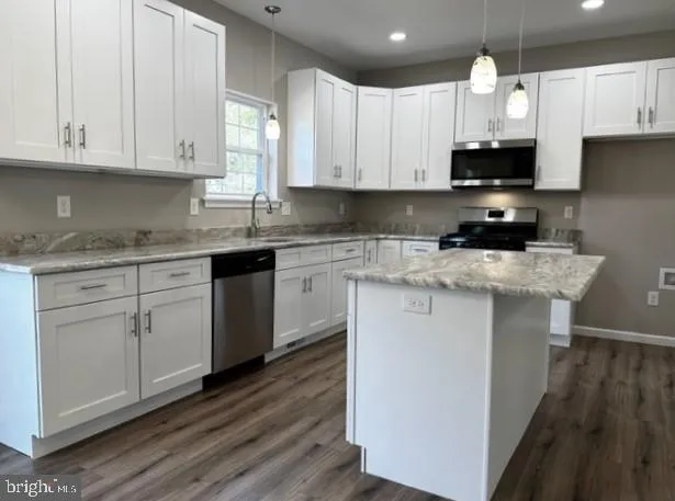 a kitchen with white cabinets appliances and sink