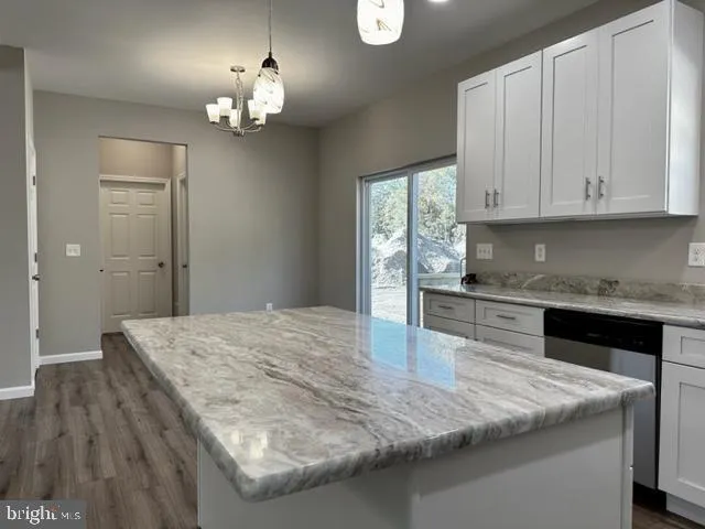 a kitchen with granite countertop a sink a stove and cabinets