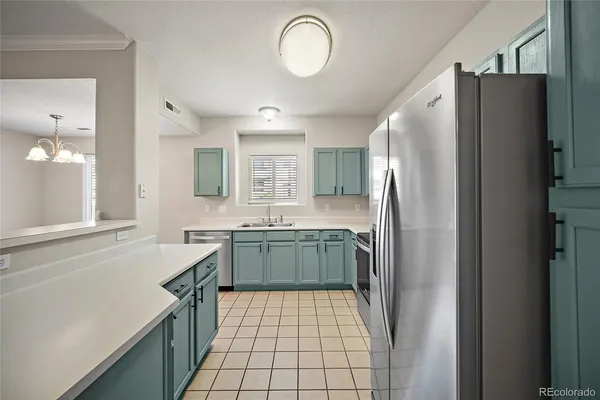 a kitchen with a refrigerator sink and cabinets