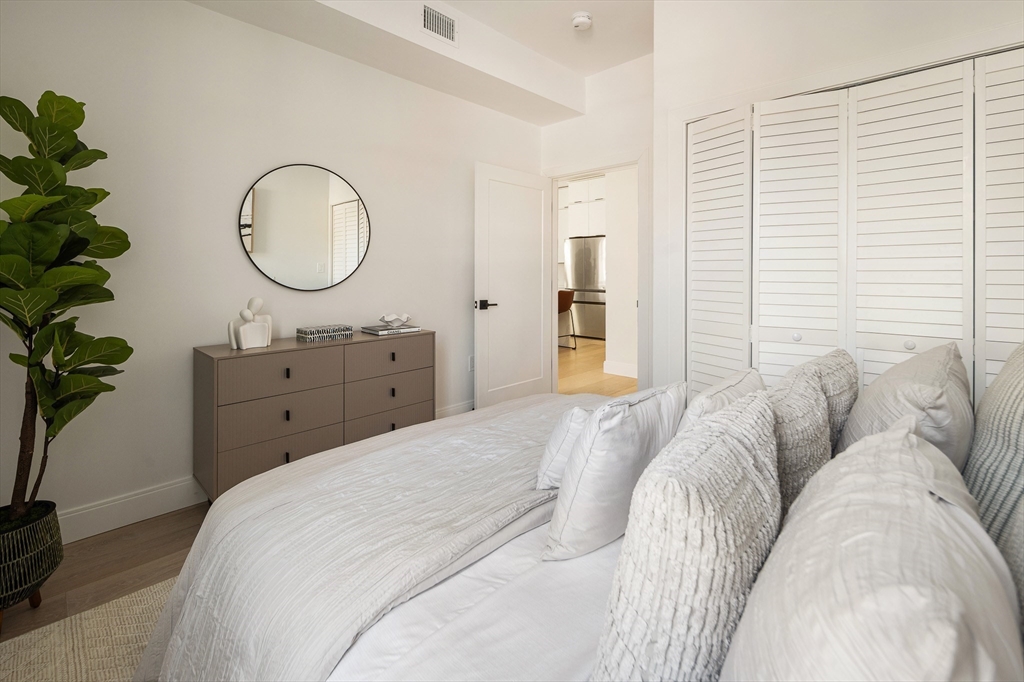 140 Shirley Street, Unit 204 Winthrop, MA 02152 - Photo 13 of 21 a bed room with a bed mirror and a potted plant