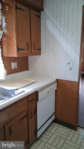 an empty room with wooden floor and windows with curtains