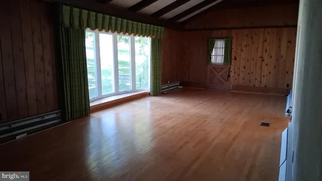 a view of room with wooden floor and fan