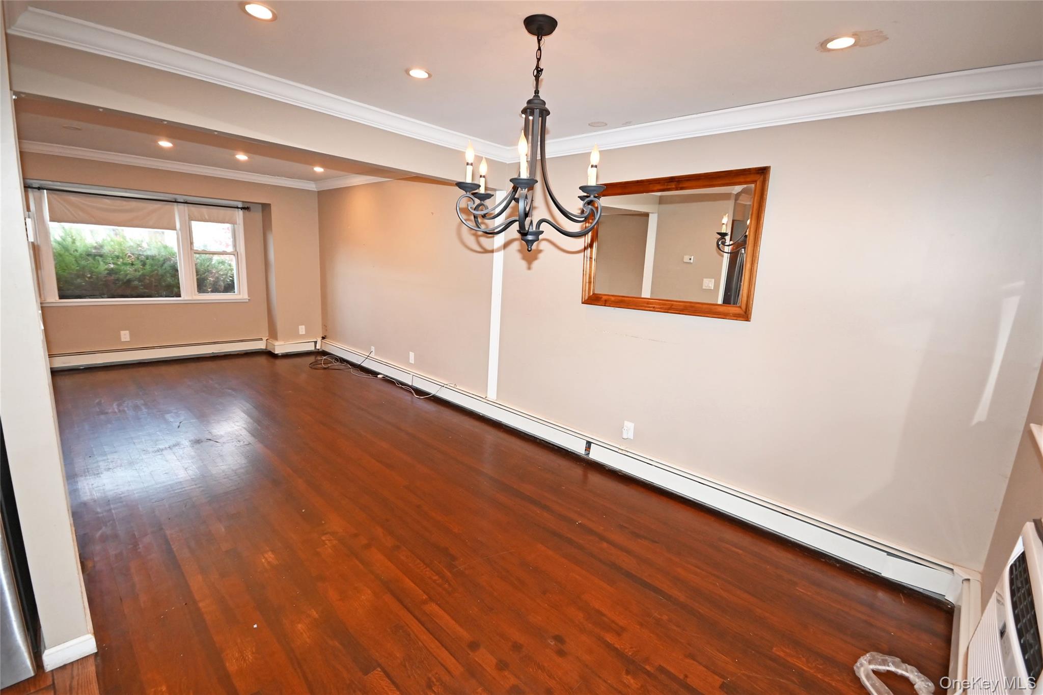 89 Osborne Road West Hempstead, NY 11552 - Photo 33 of 50 Unfurnished room featuring dark wood finished floors, a baseboard heating unit, crown molding, recessed lighting, and a chandelier