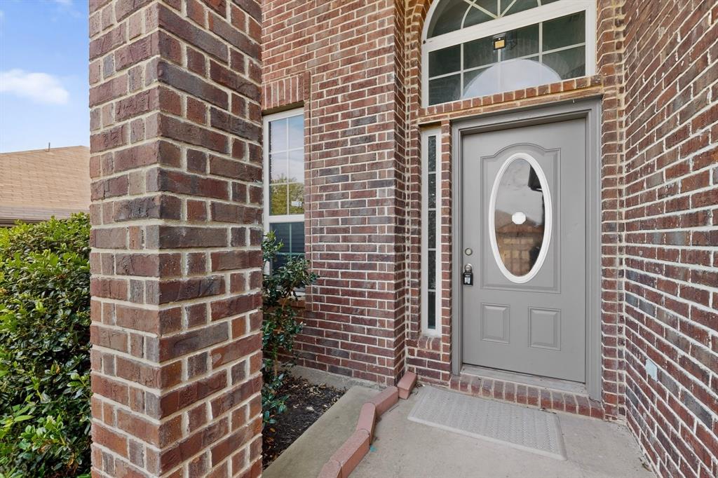 426 Harding Lane Lavon, TX 75166 - Photo 3 of 40 Brick exterior with a gray front door, oval glass insert, and transom window