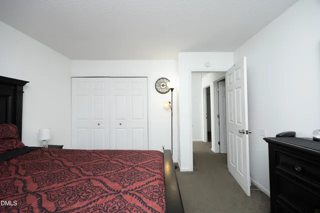 a bedroom with a bed and a flat tv screen on dresser