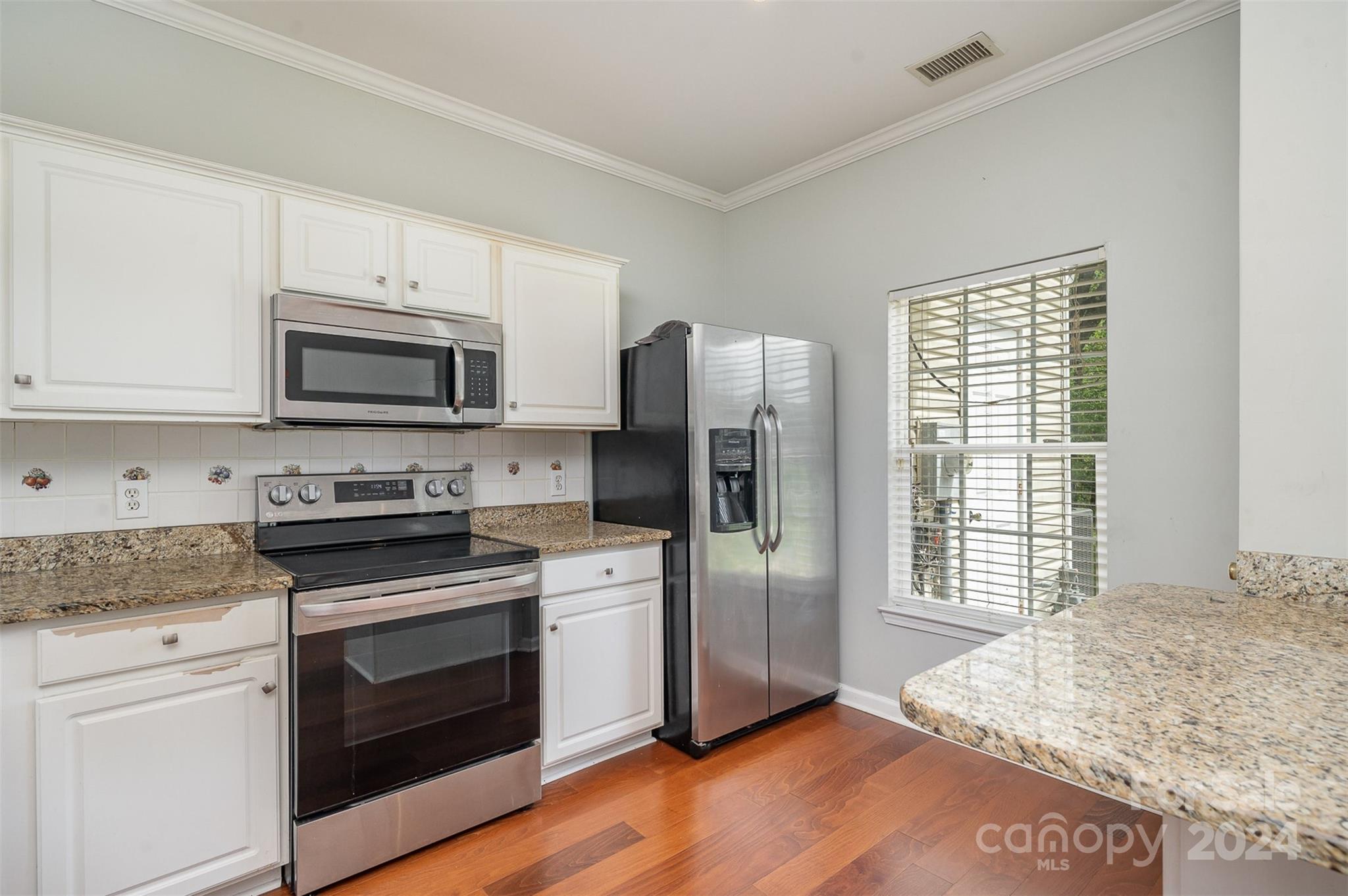 6604 Rothchild Drive Charlotte, NC 28270 - Photo 5 of 32 a kitchen with granite countertop a refrigerator stove and microwave