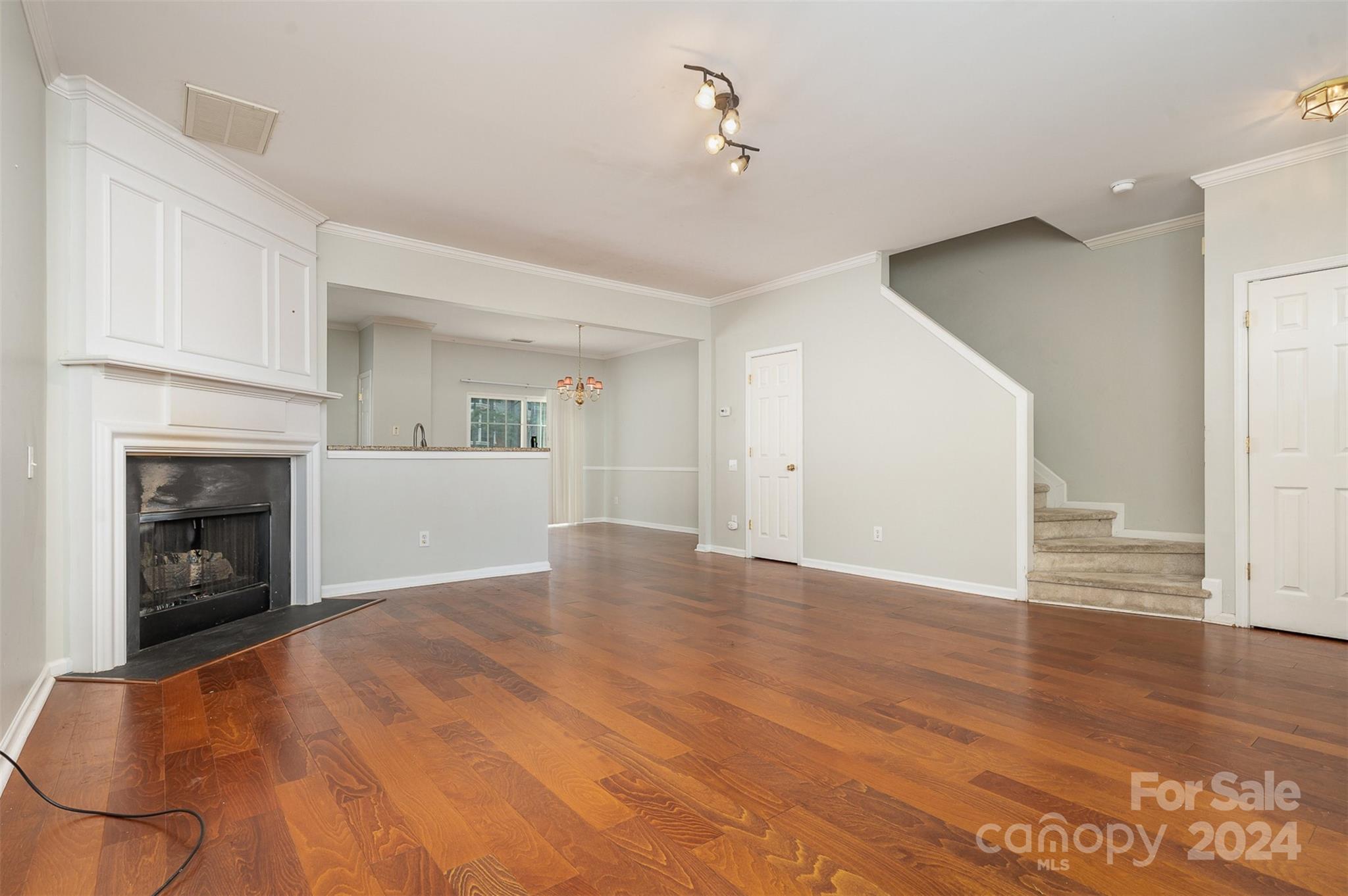6604 Rothchild Drive Charlotte, NC 28270 - Photo 10 of 32 a view of empty room with wooden floor and fireplace