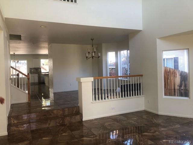 Undisclosed Address Commerce City, CO 80022 - Photo 3 of 12 a view of a hallway with entryway and chandelier
