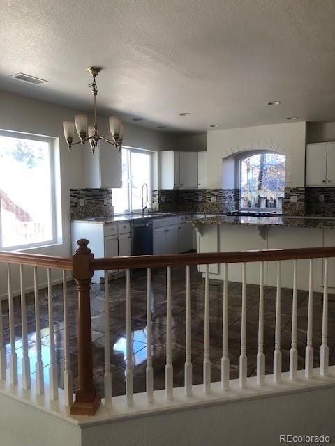 Undisclosed Address Commerce City, CO 80022 - Photo 7 of 12 a kitchen with sink cabinets and chandelier