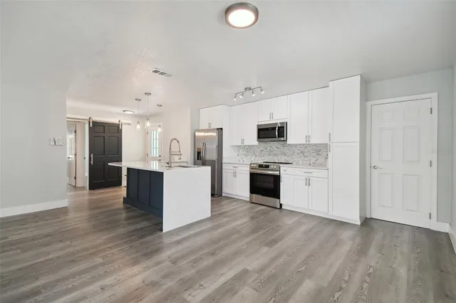 a large kitchen with a center island and stainless steel appliances