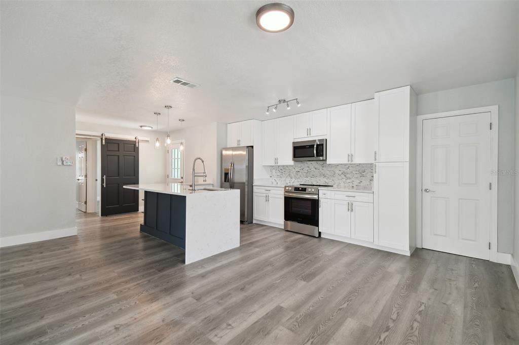 4482 Kingston Drive Hernando Beach, FL 34607 - Photo 12 of 49 a large kitchen with a center island and stainless steel appliances