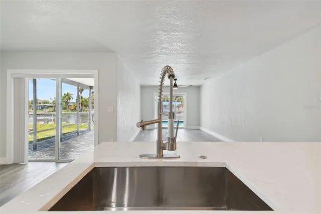a view of a kitchen with kitchen island a sink and a large window