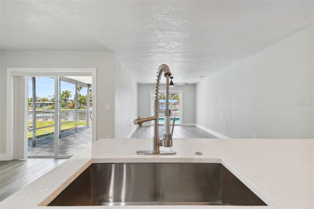 4482 Kingston Drive Hernando Beach, FL 34607 - Photo 15 of 49 a view of a kitchen with kitchen island a sink and a large window