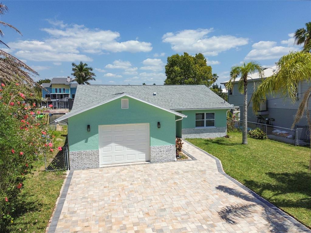 4482 Kingston Drive Hernando Beach, FL 34607 - Photo 2 of 49 a front view of a house with a yard and garage