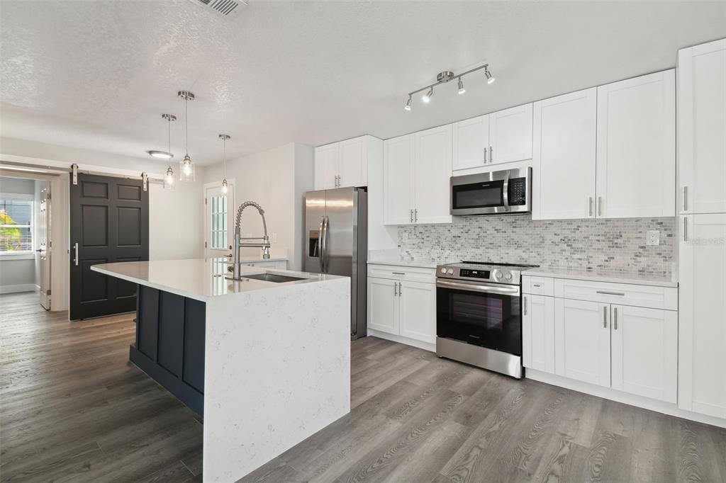 4482 Kingston Drive Hernando Beach, FL 34607 - Photo 21 of 49 a large kitchen with cabinets wooden floor and stainless steel appliances