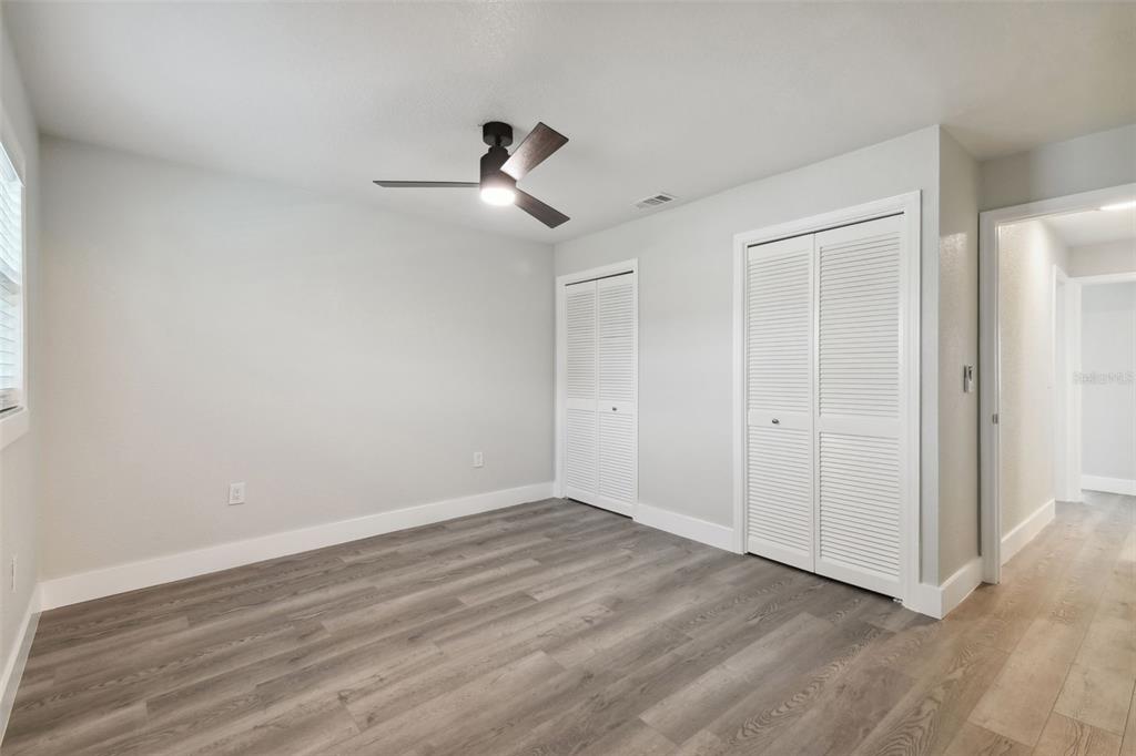 4482 Kingston Drive Hernando Beach, FL 34607 - Photo 27 of 49 a view of empty room with wooden floor and ceiling fan