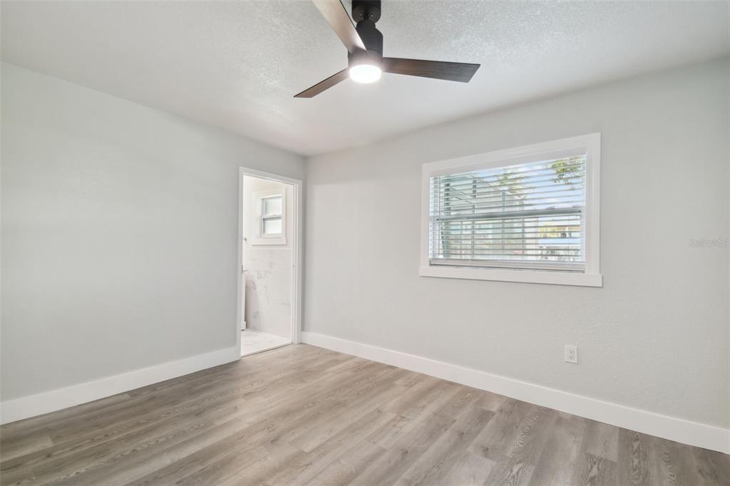 4482 Kingston Drive Hernando Beach, FL 34607 - Photo 28 of 49 a view of an empty room with wooden floor and a window
