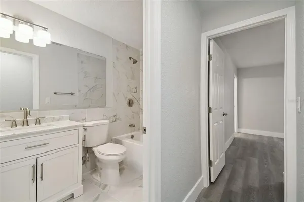 a bathroom with a toilet a sink a mirror a vanity and shower