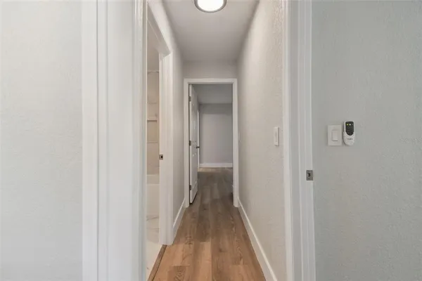 a view of a hallway with wooden floor