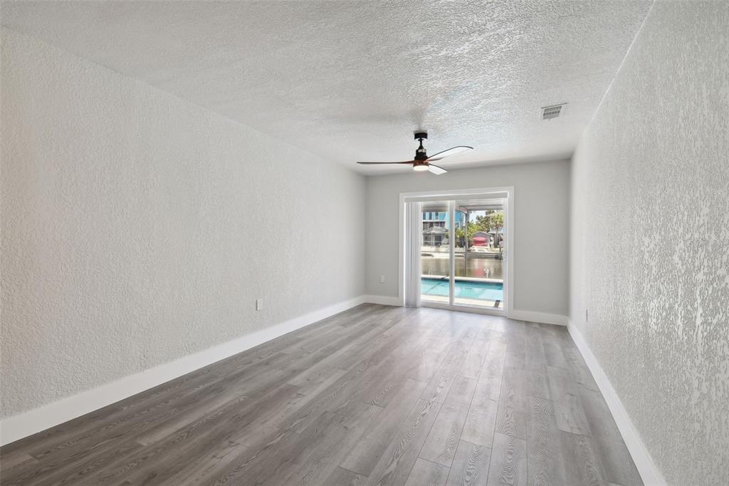 4482 Kingston Drive Hernando Beach, FL 34607 - Photo 10 of 49 wooden floor in an empty room with a window