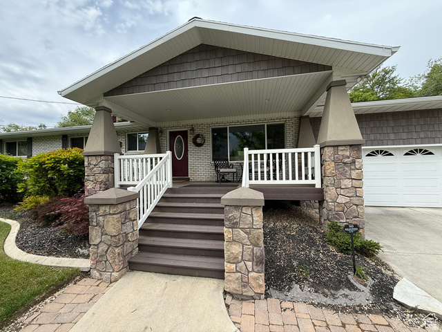 1360 Carterville Road Orem, UT 84097 - Photo 22 of 40 View of front of home with covered porch, a garage, concrete driveway, and brick siding