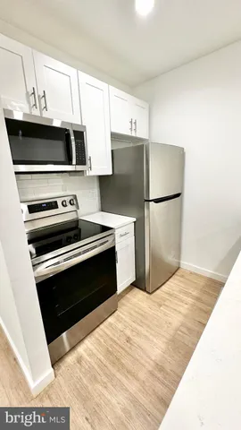a kitchen with kitchen island a sink a stove and white cabinets