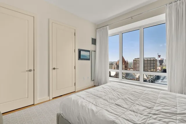 a bedroom with a bed and a large window