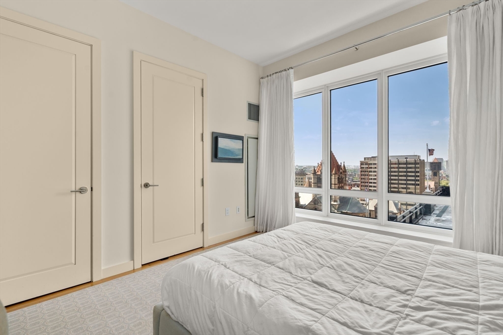 400 Stuart Street, Unit 15J Boston, MA 02116 - Photo 5 of 12 a bedroom with a bed and a large window