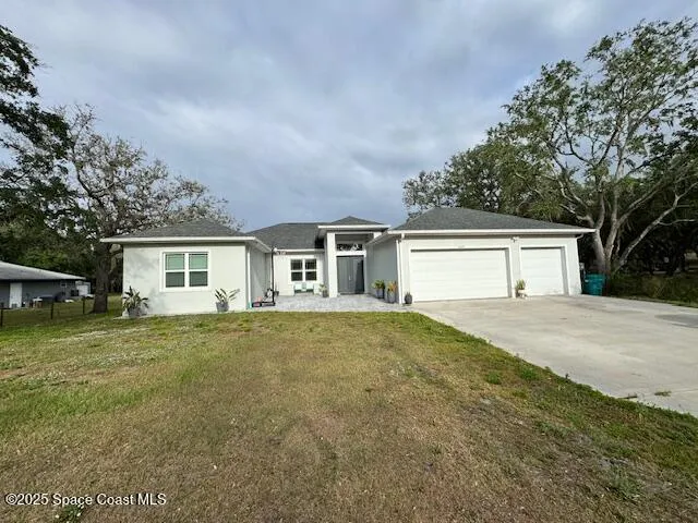 a front view of house with yard and trees