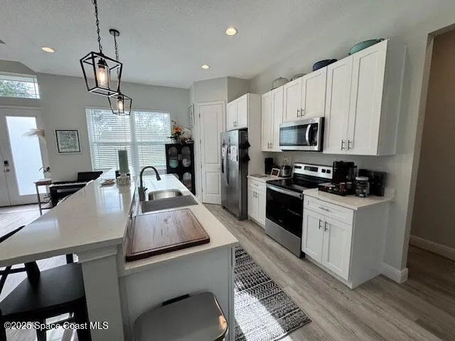 a kitchen with kitchen island a white counter top space a sink and appliances