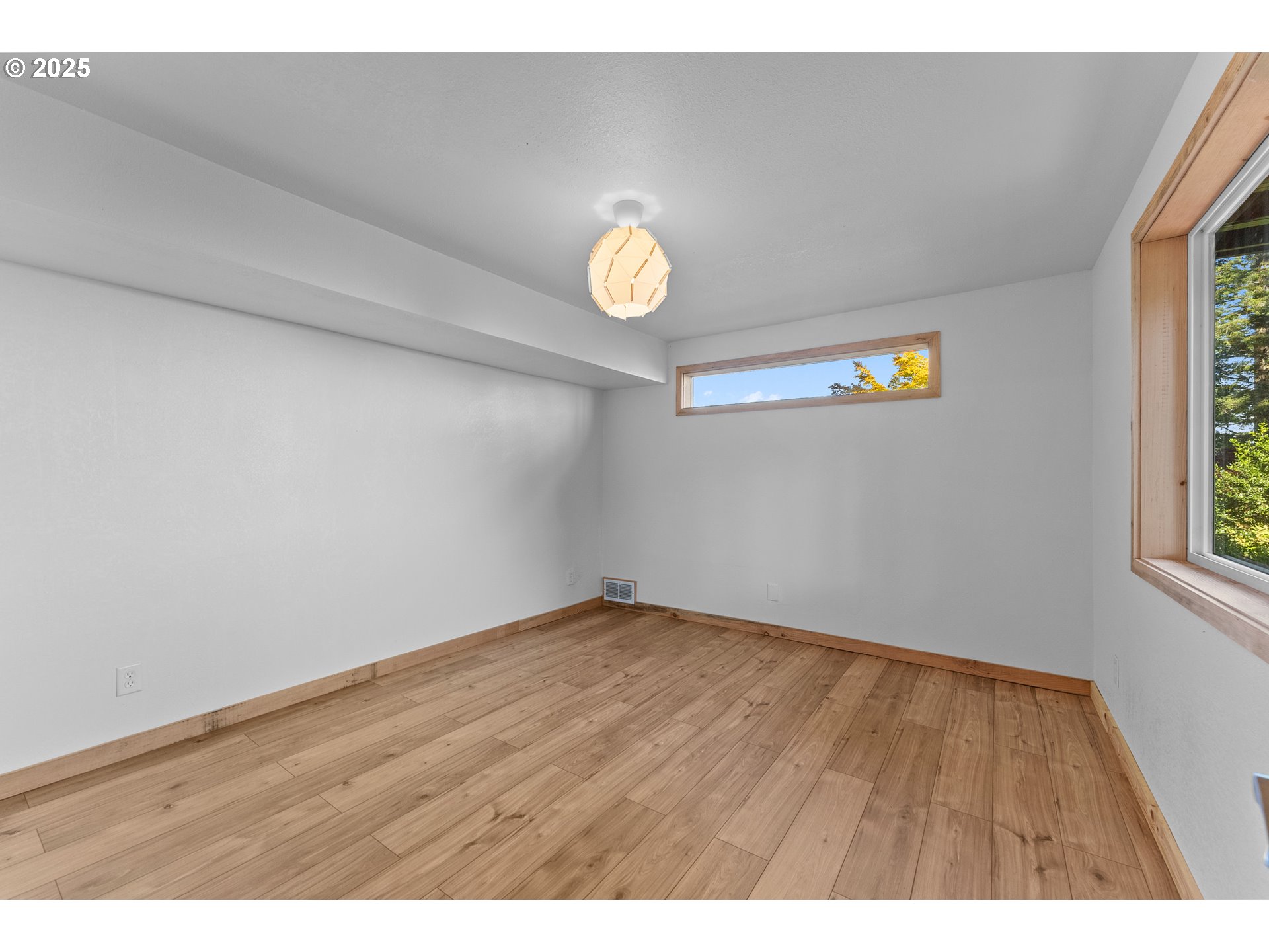 97639 Marina Heights Loop Brookings, OR 97415 - Photo 14 of 27 a view of an empty room with window and wooden floor