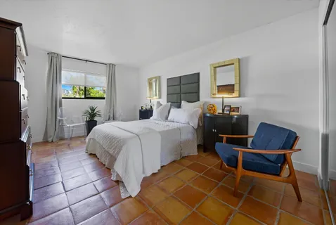 a bedroom with a bed and a mirror