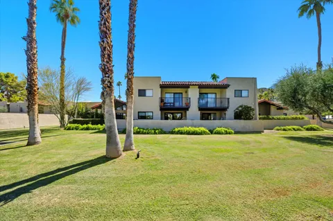 a front view of a house with a yard and potted plants