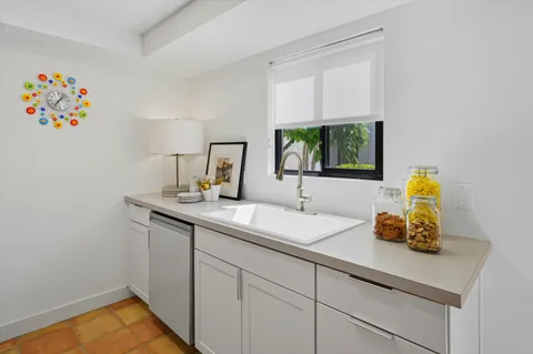 a kitchen with stainless steel appliances granite countertop white cabinets a stove a sink and dishwasher
