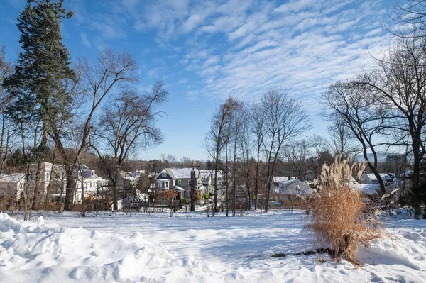 a view of a yard covered with snow in front of house