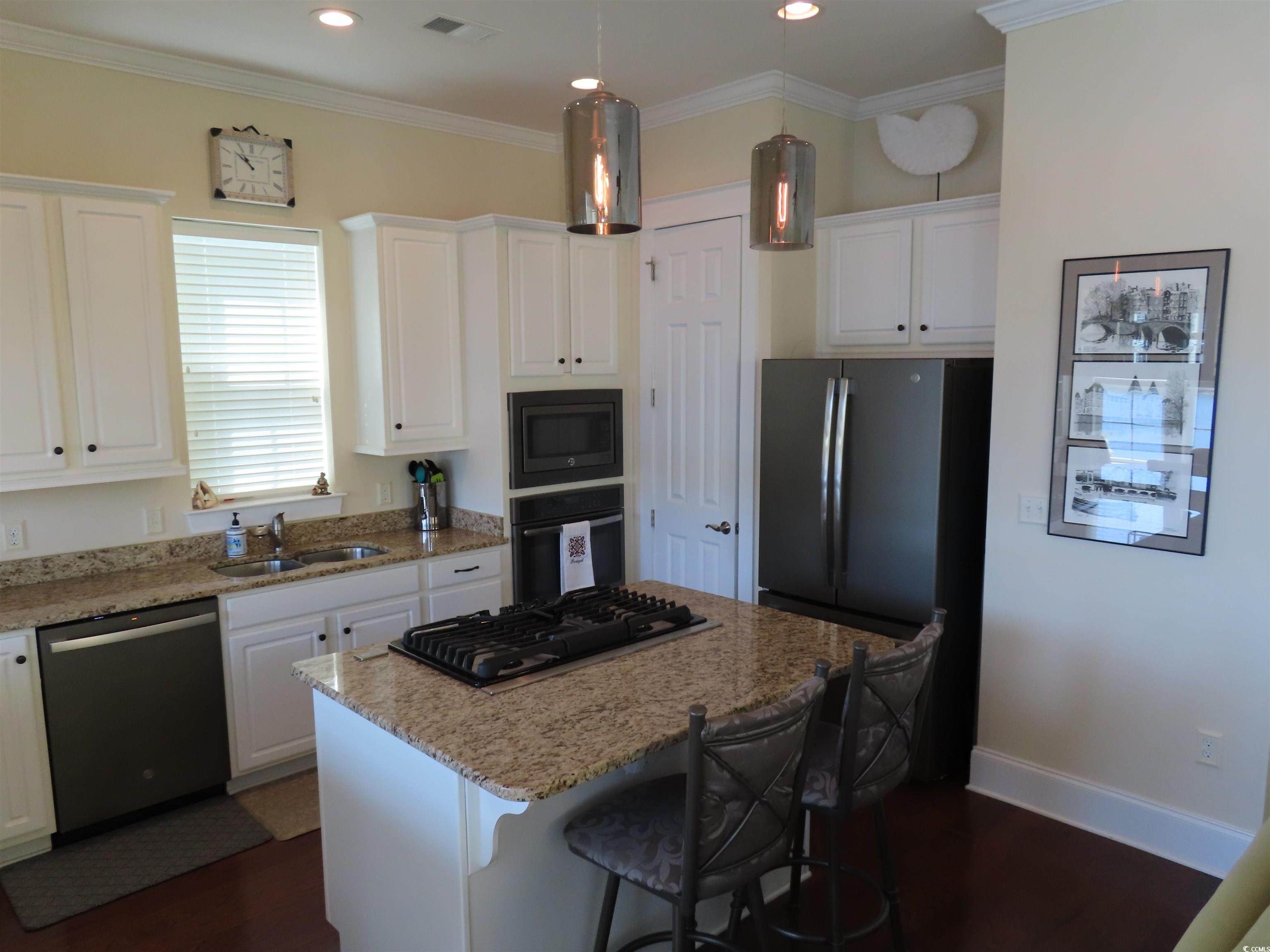 800 Curtis Brown Lane Myrtle Beach, SC 29577 - Photo 12 of 40 Kitchen featuring a kitchen breakfast bar, light stone countertops, black appliances, white cabinetry, and dark wood-style floors