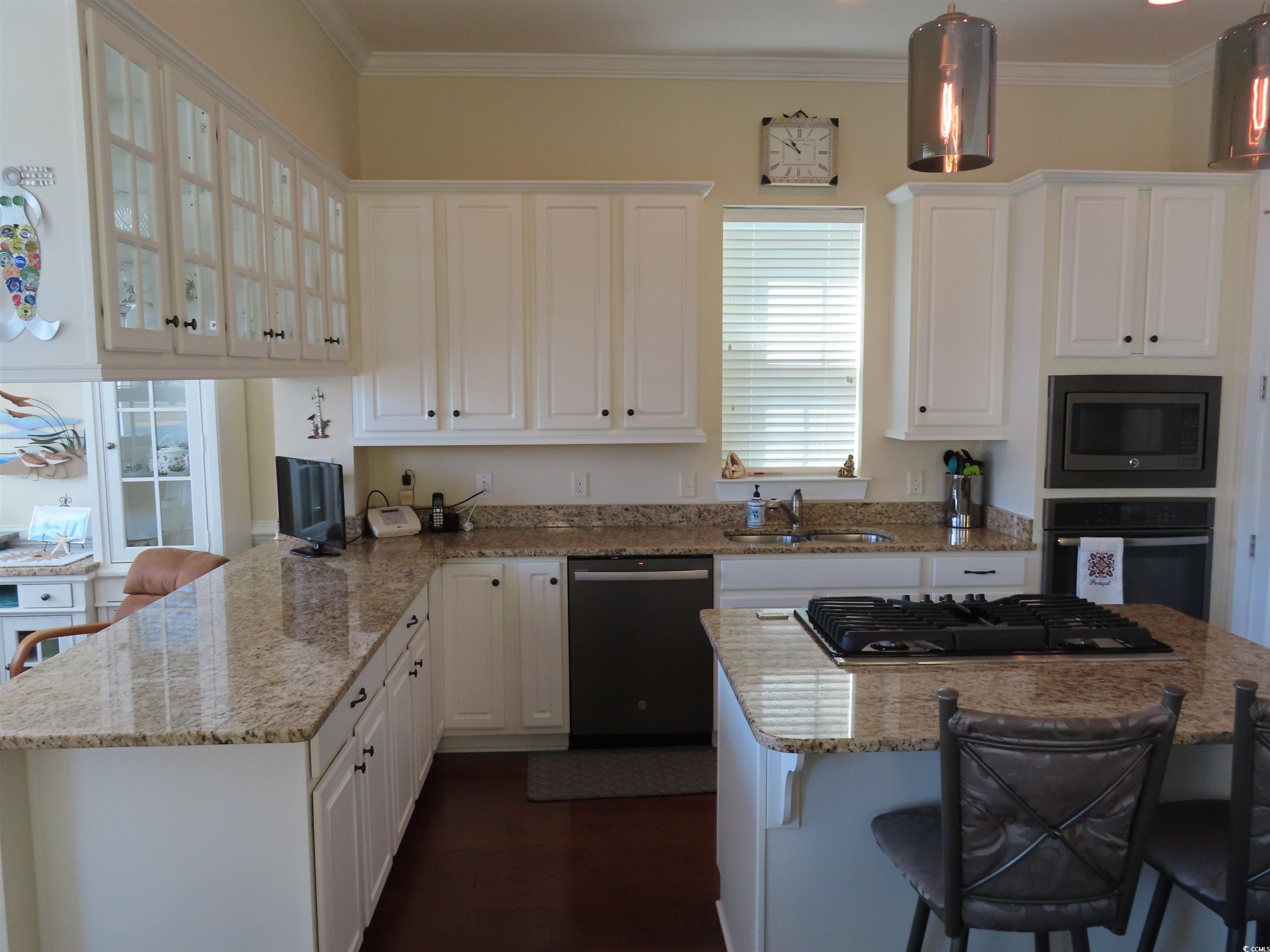 800 Curtis Brown Lane Myrtle Beach, SC 29577 - Photo 13 of 40 Kitchen with a breakfast bar, light stone countertops, stainless steel appliances, and crown molding