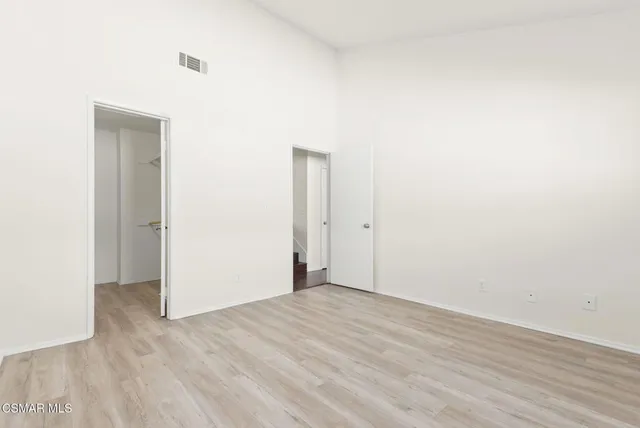 an empty room with wooden floor and window